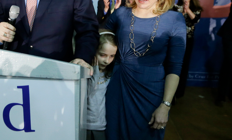Caroline Cruz appears to cover her ears as her father speaks at a Des Moines, Iowa, caucus night rally in February, trapped between the rigid bodies of her smiling parents. The nearest exit is impossibly far. (AP)
